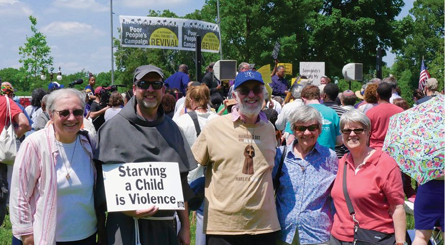 Patrick Carolan (center) is flanked by Sister Maria Orlandi, OSF, Father Mike Laskey, Sister Marie Lucey, OSF, and Sister Ann Schult, SSND, at a rally for social justice.