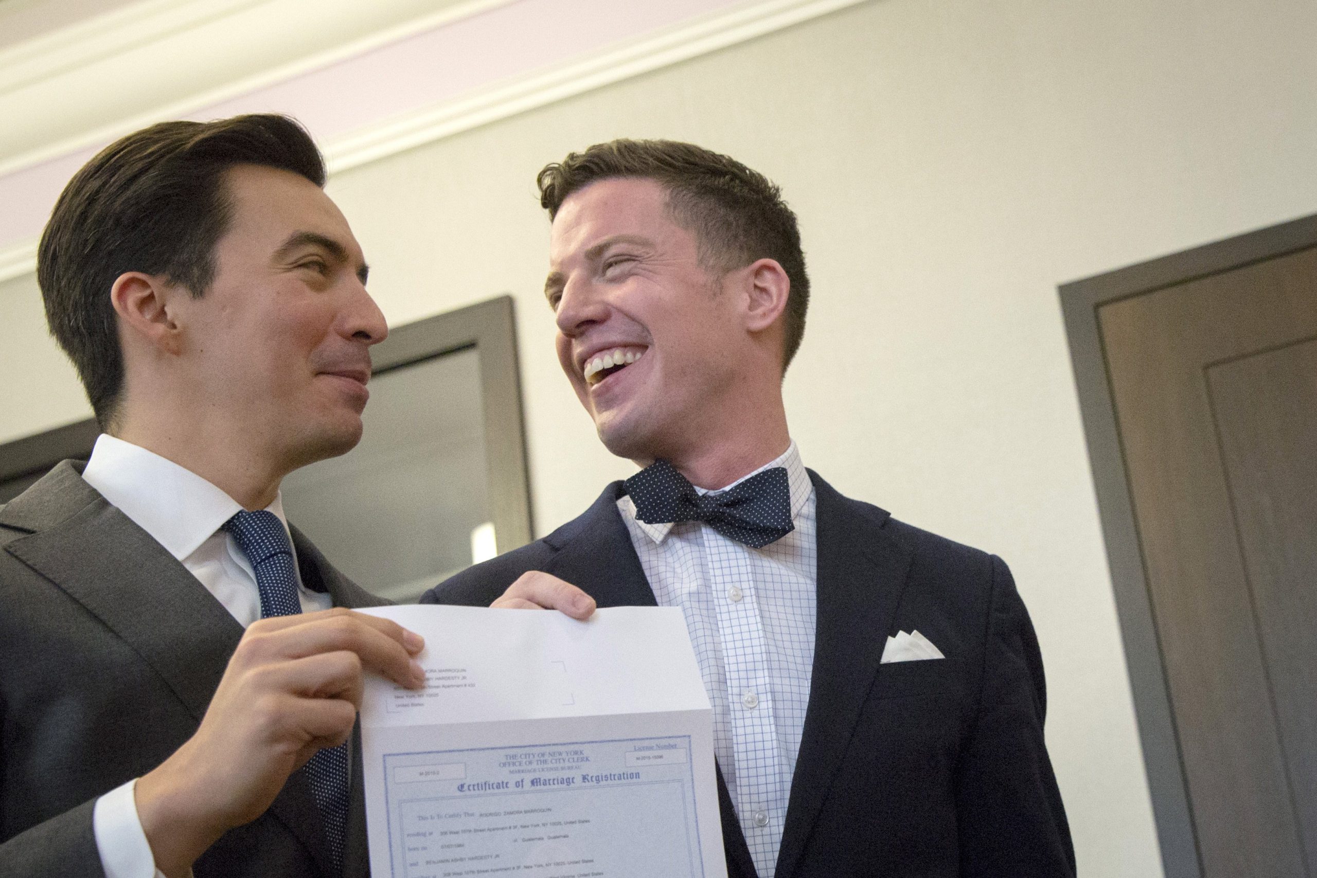 Rodrigo Zamora, left, and Ashby Hardesty show their marriage license to friends at the New York City clerk's office after their wedding in Manhattan June 26, 2015. That day the U.S. Supreme Court ruled the U.S. Constitution provides same-sex couples the right to marry. On Sept. 15, 2022, the U.S. Senate delayed vote on a bill that would codify same-sex marriage until after the midterm elections. (CNS photo/Brendan McDermid, Reuters)