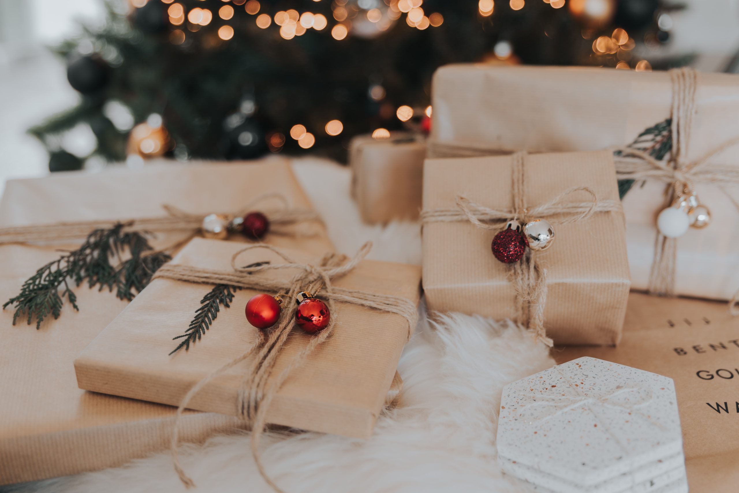 Christmas gifts under a tree | Photo by Lore Schodts on Unsplash