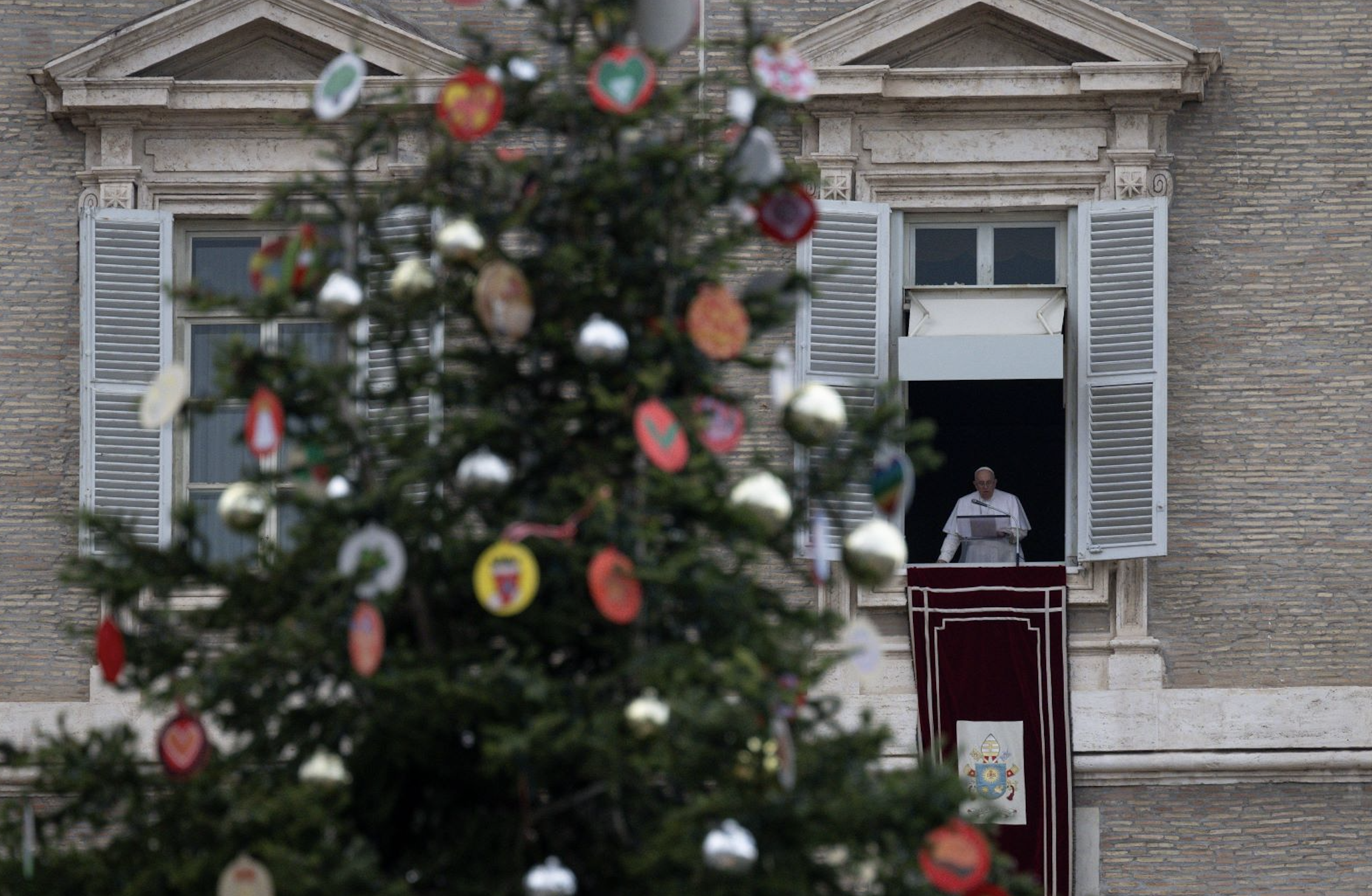 The Christmas tree in St. Peter's Square is seen as Pope Francis leads the Angelus from the window of his studio overlooking the square at the Vatican Dec. 4, 2022. (CNS photo/Vatican Media)