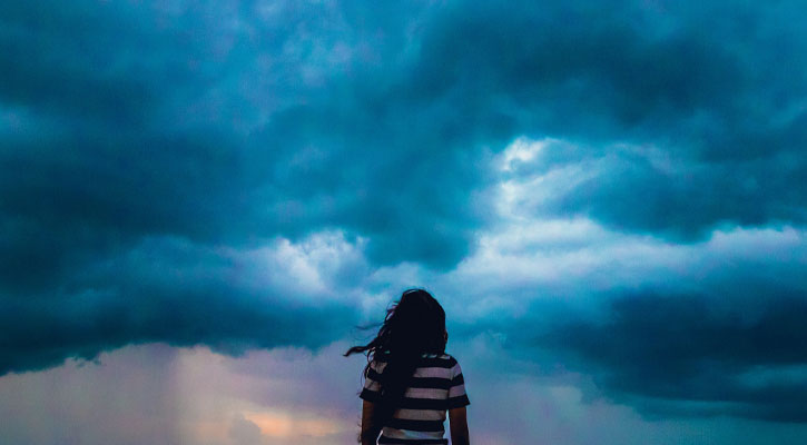 Woman looking at storm clouds
