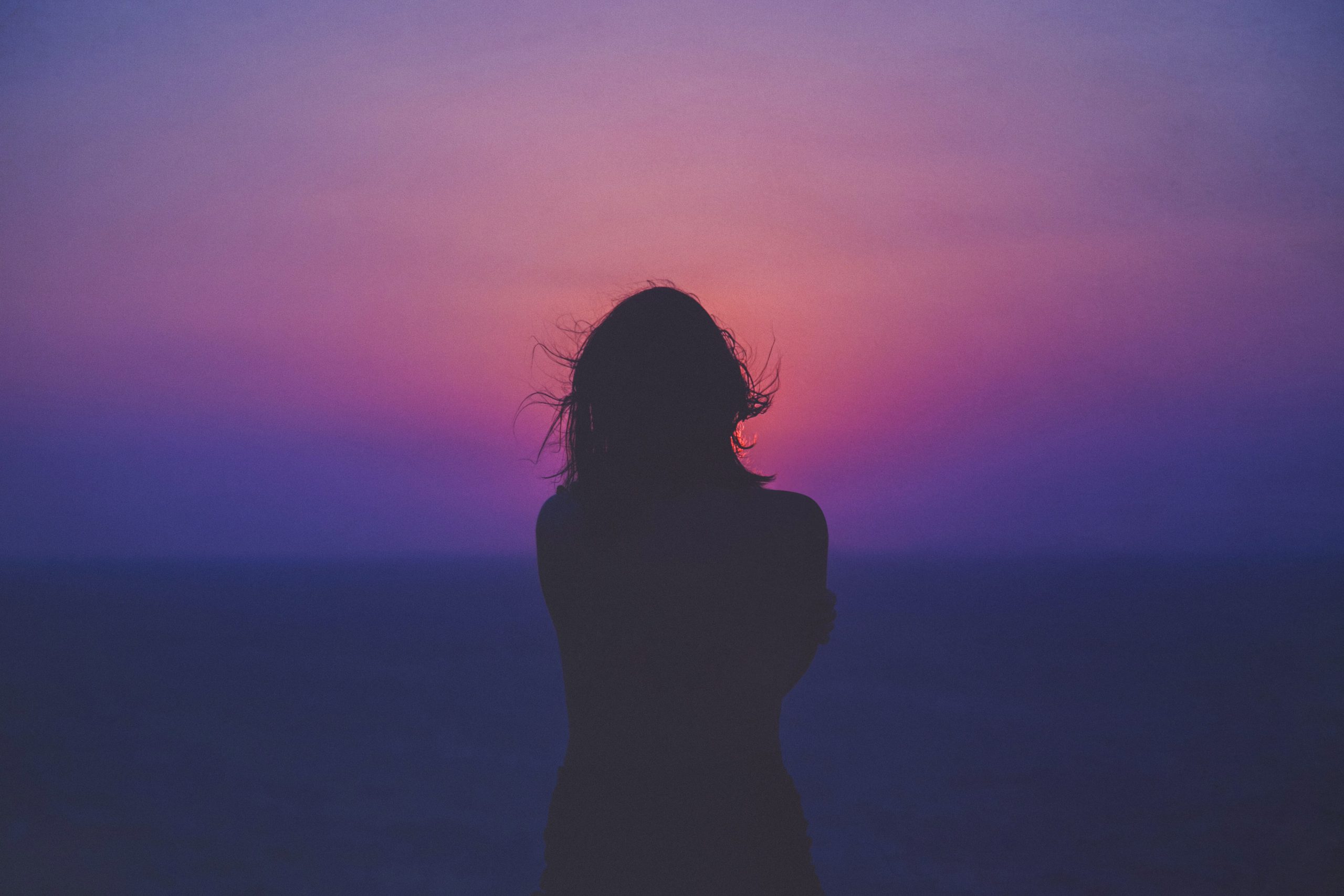 Woman looking at the sunrise | Image: Unsplash