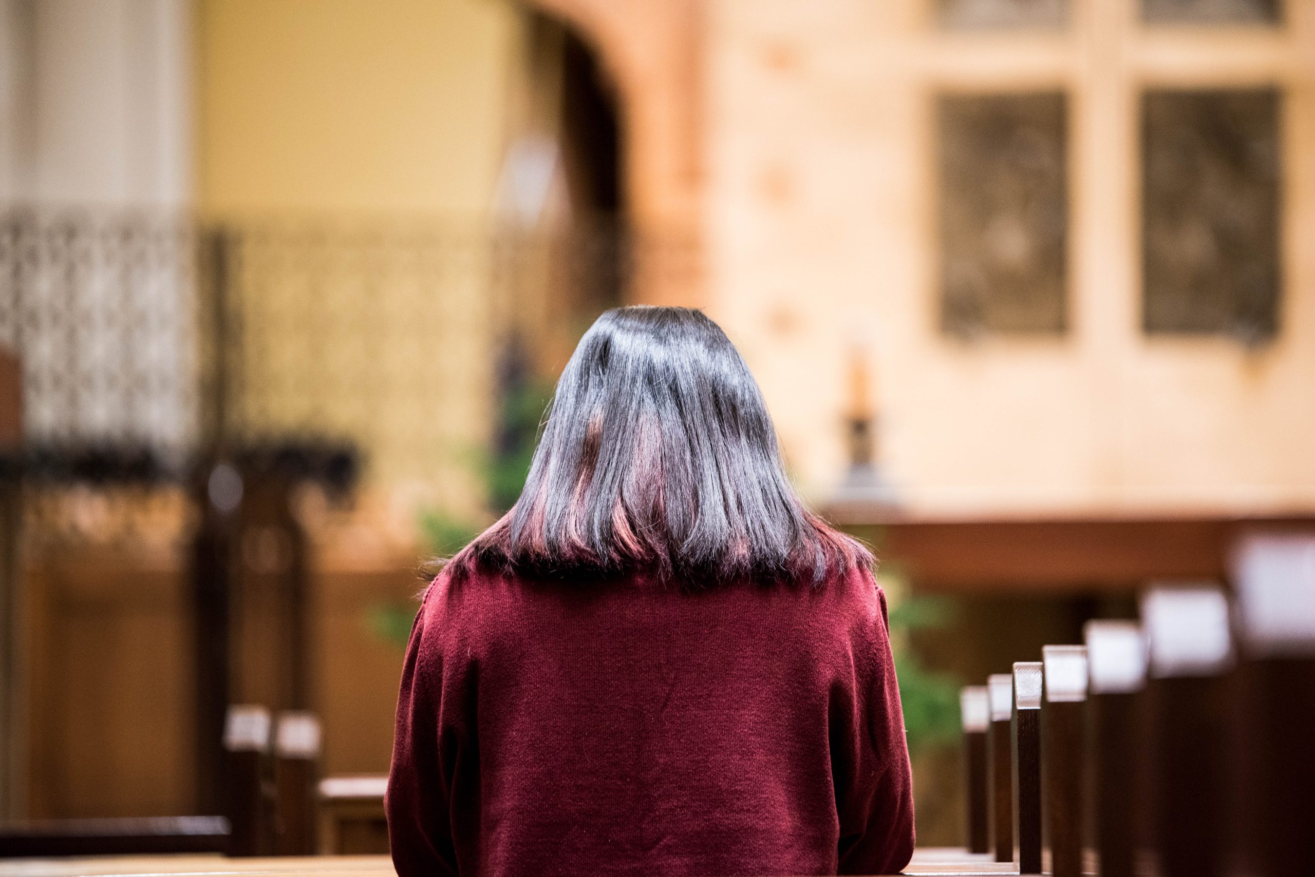 Woman praying in church | Photo by Gianna Bonello on Unsplash