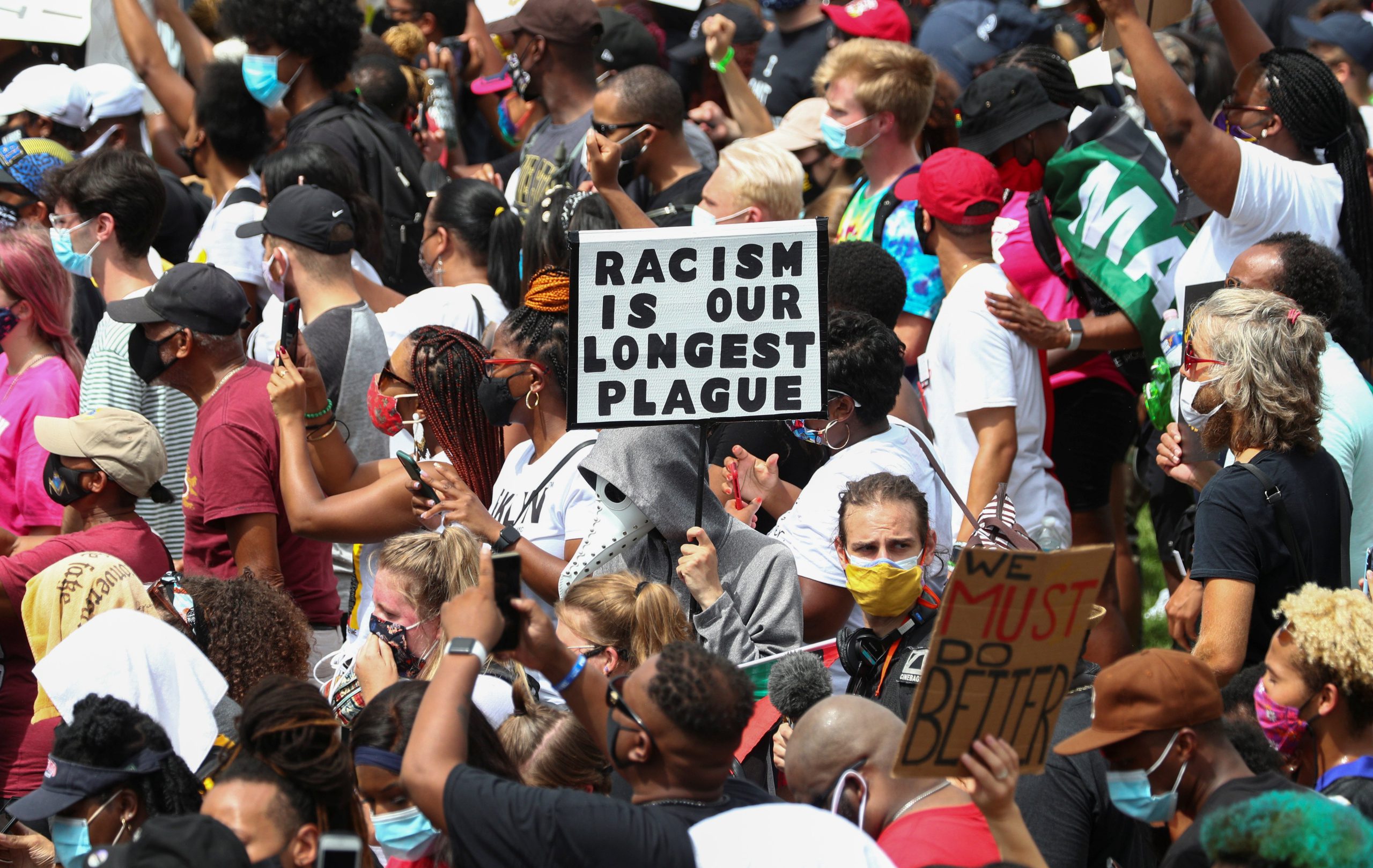 Protesters stand with a sign reading "Racism Is Our Longest Plague" in Washington Aug. 28, 2020, during the "Get Your Knee Off Our Necks" Commitment March on Washington 2020 in support of racial justice. (CNS photo/Tom Brenner, Reuters)