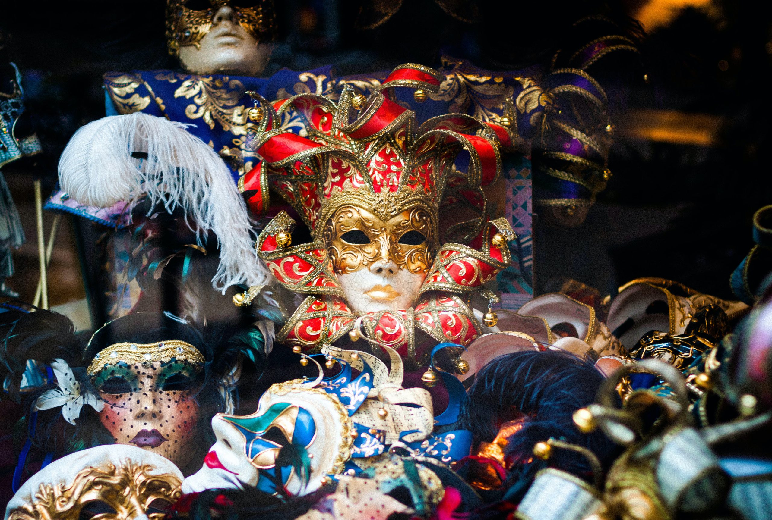 Fat Tuesday masks in a store window | Photo by Llanydd Lloyd on Unsplash