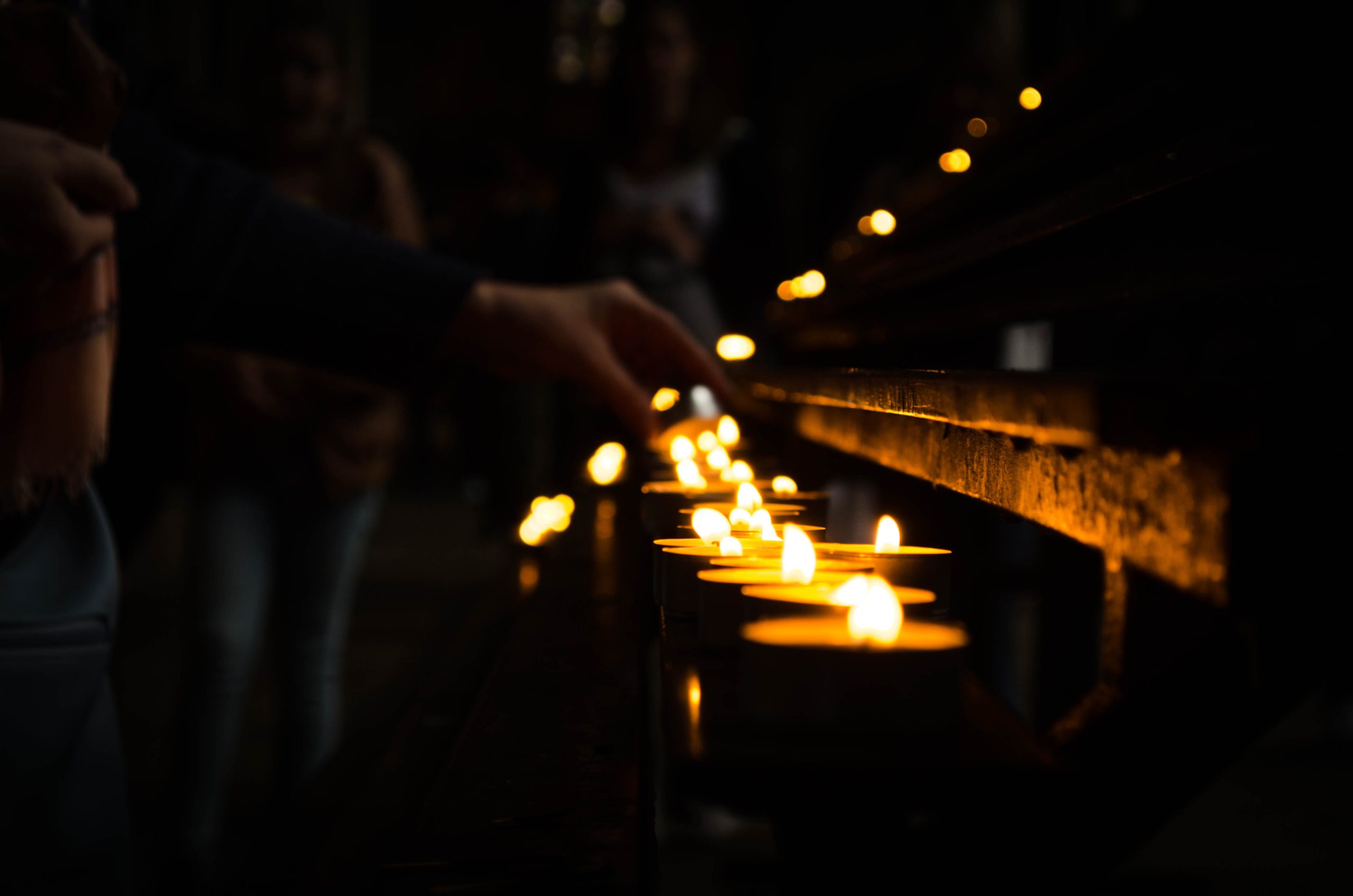 People lighting candles | Photo by Jose Antonio Gallego Vázquez on Unsplash