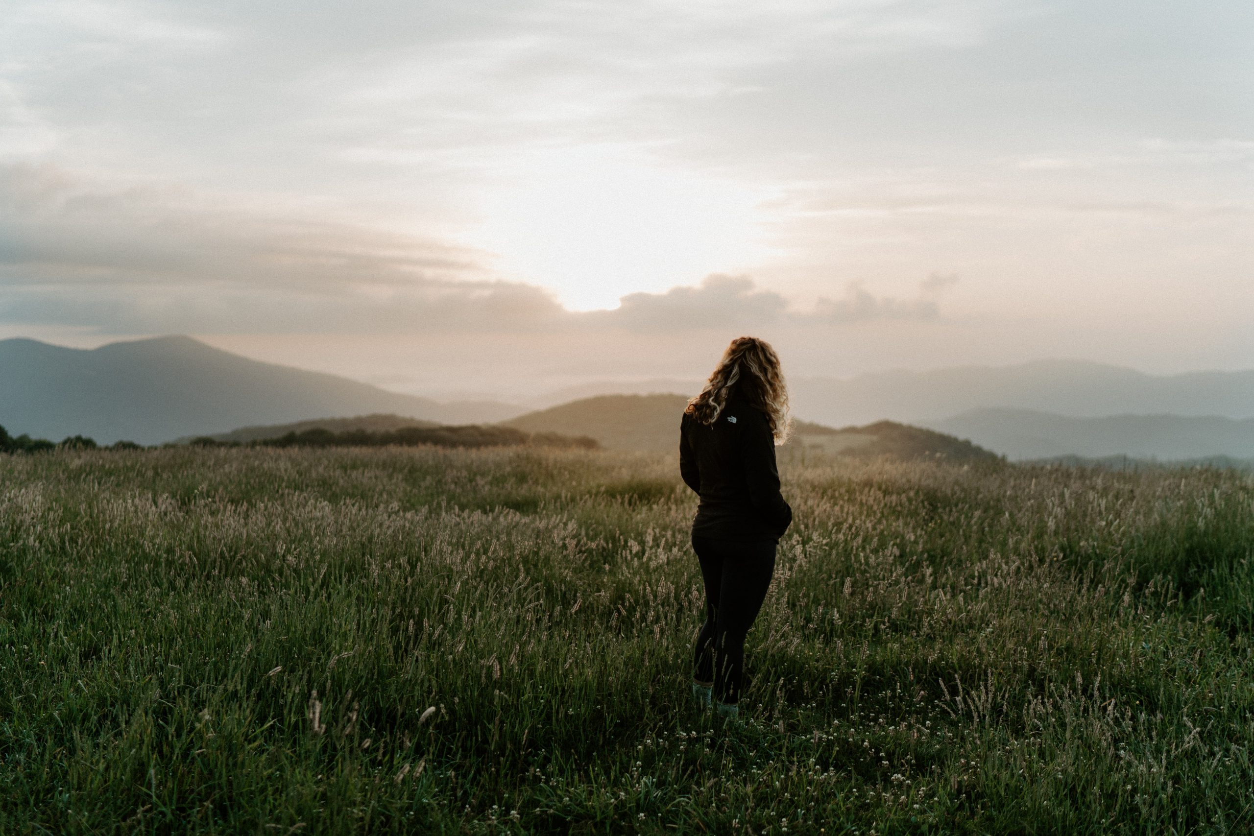 Woman looking at the sunrise | Photo by Brittani Burns on Unsplash